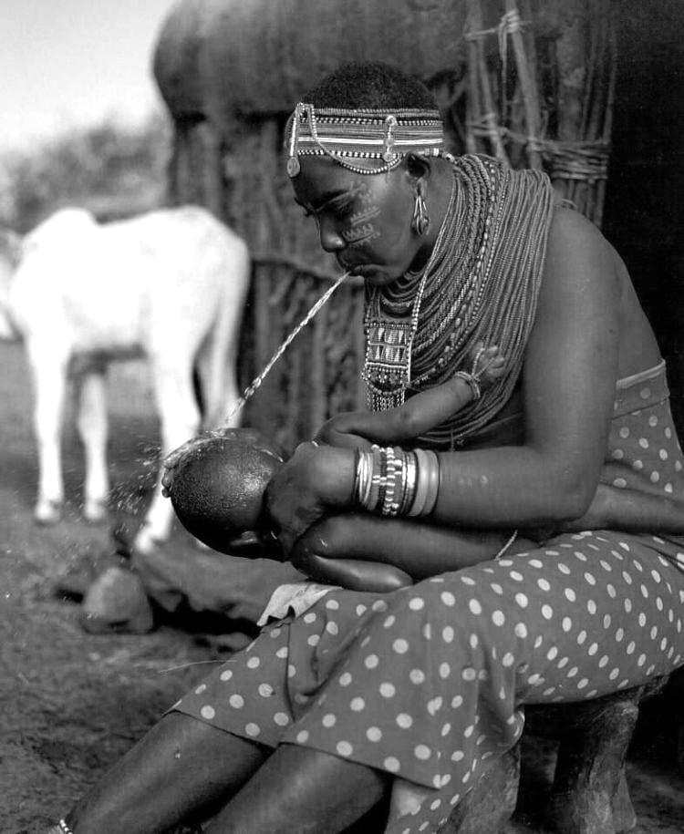 A Maasai mother blesses her new baby by spitting on her