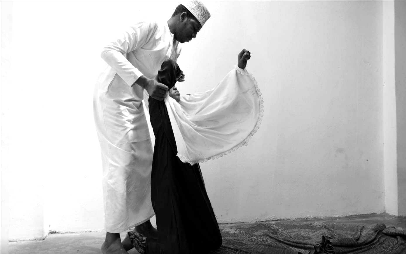Sheikh trying to wake a woman by pouring water on her neck - Zanzibar