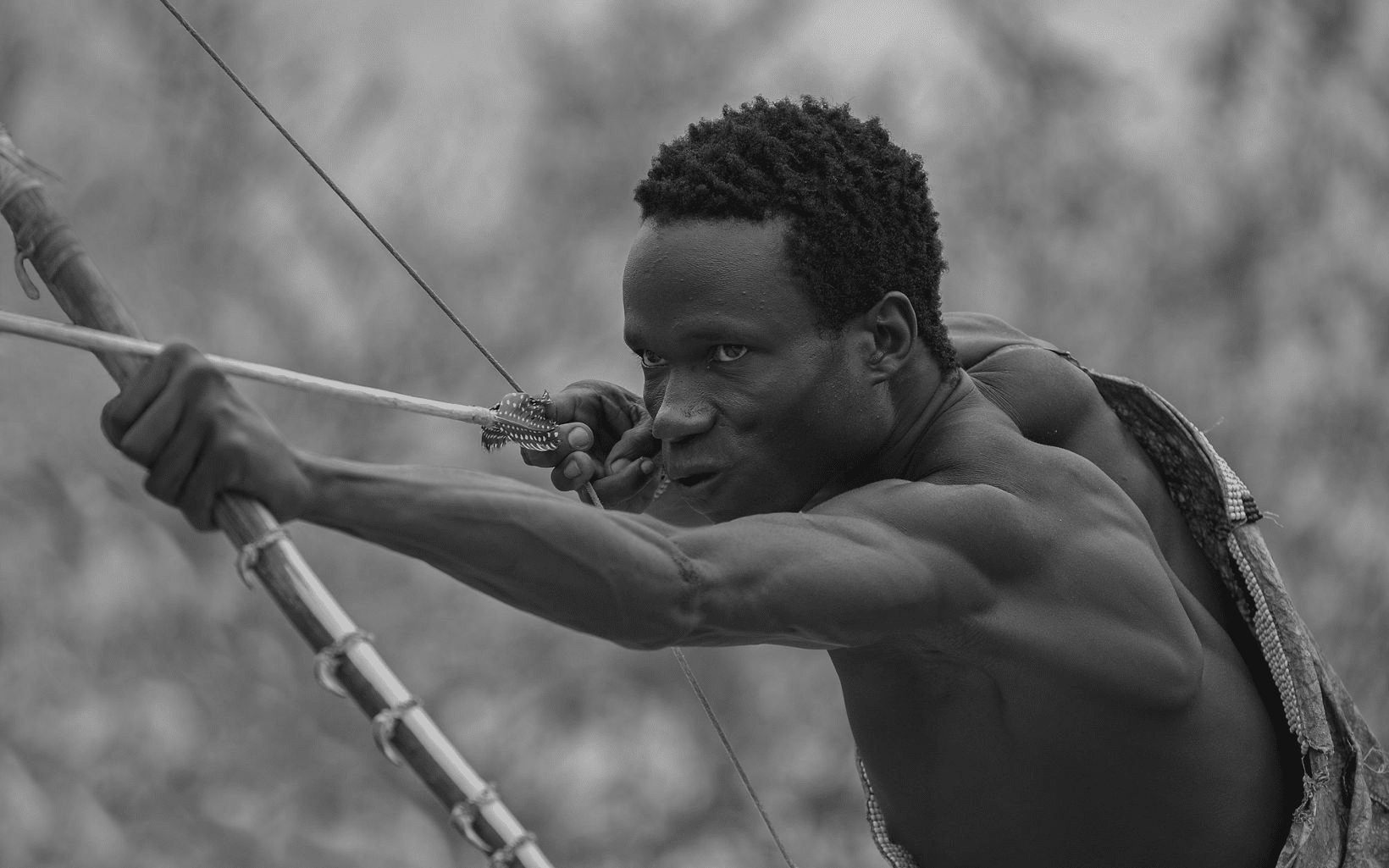 Hadza tribe man practising shooting with an arrow