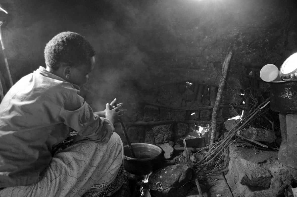 Woman in a village hut cooking in Tanzania