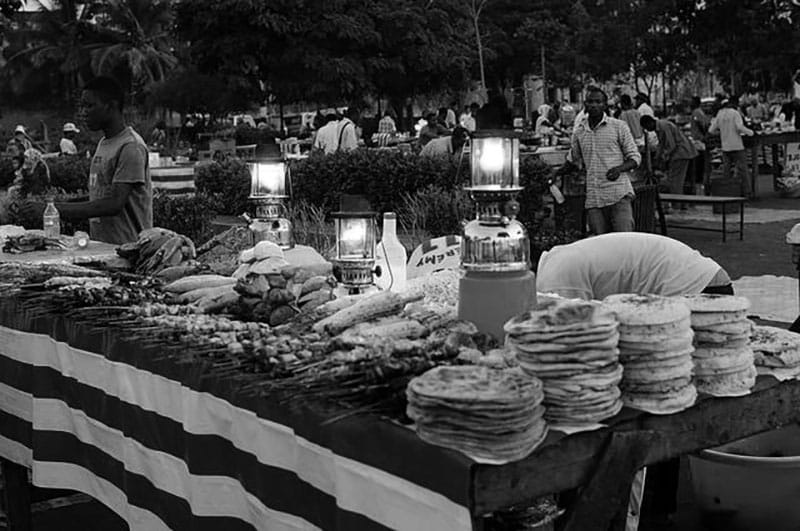 Vendors at Forodhani gardens in Stone town zanzibar with customers mingling around