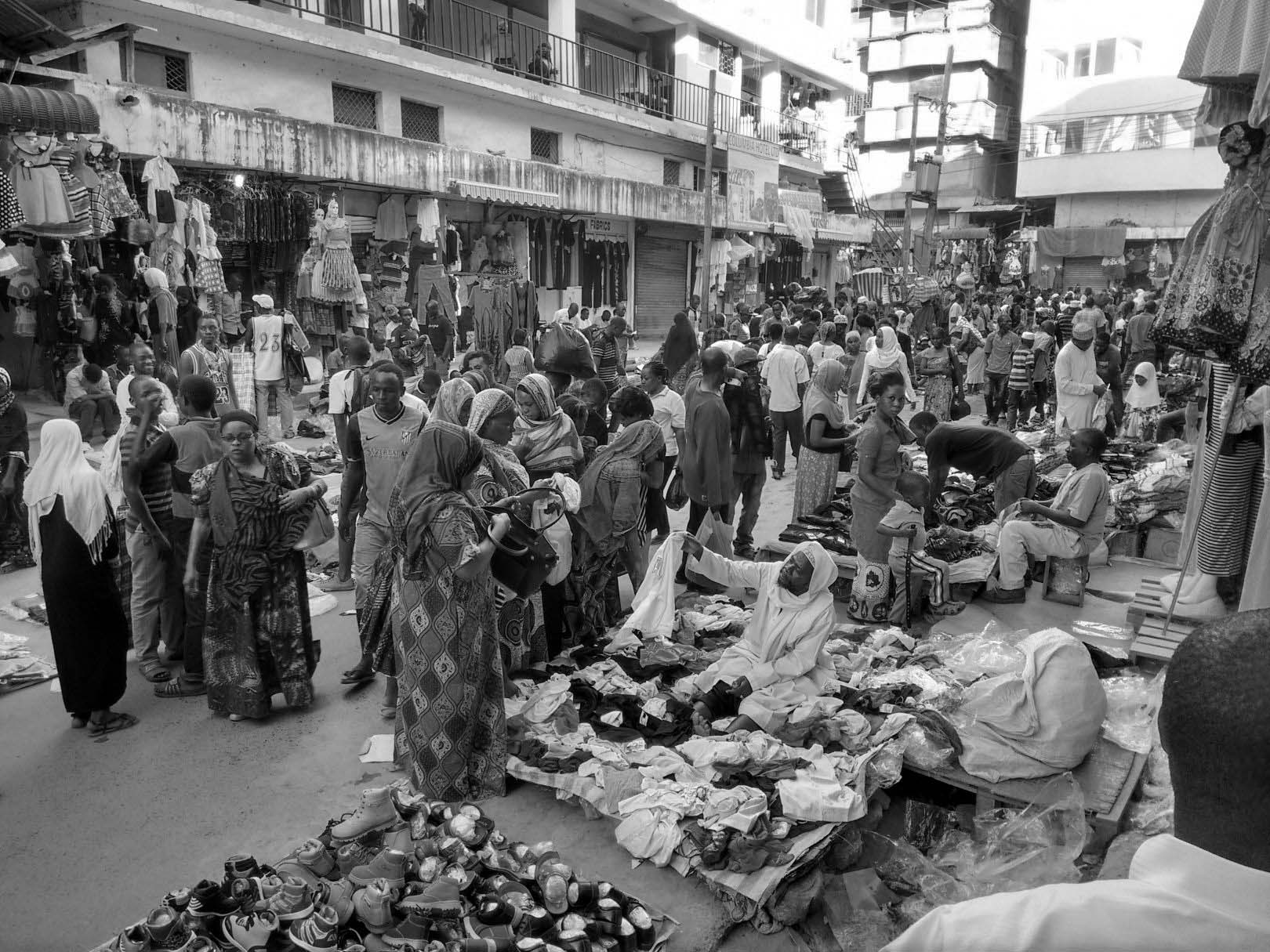 Vendors and a crowd of people trading outside the Kariakoo market building