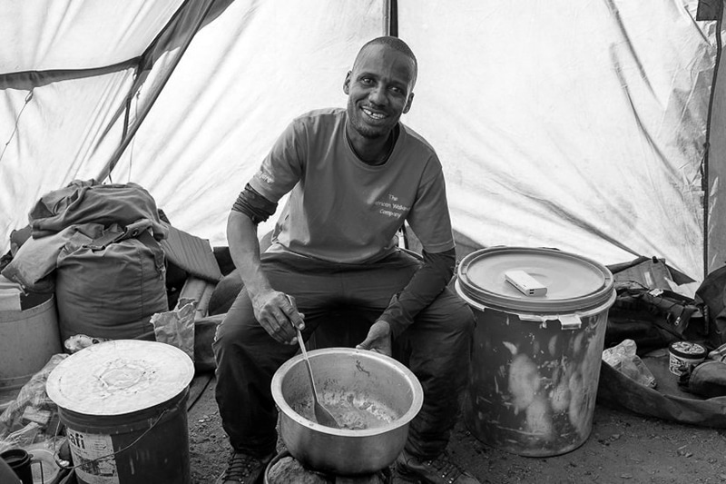 A Kilimanjaro porter preparing food for climbers