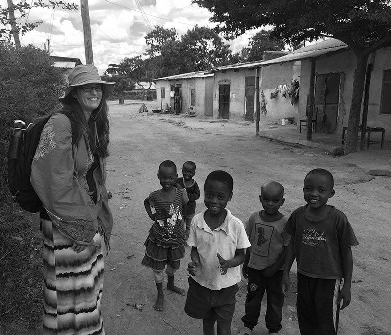 A Peace Corps Tanzania volunteer chatting with children along the road