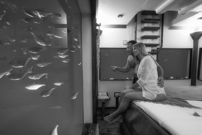 A couple at Pemba Underwater Hotel watching fish in their room