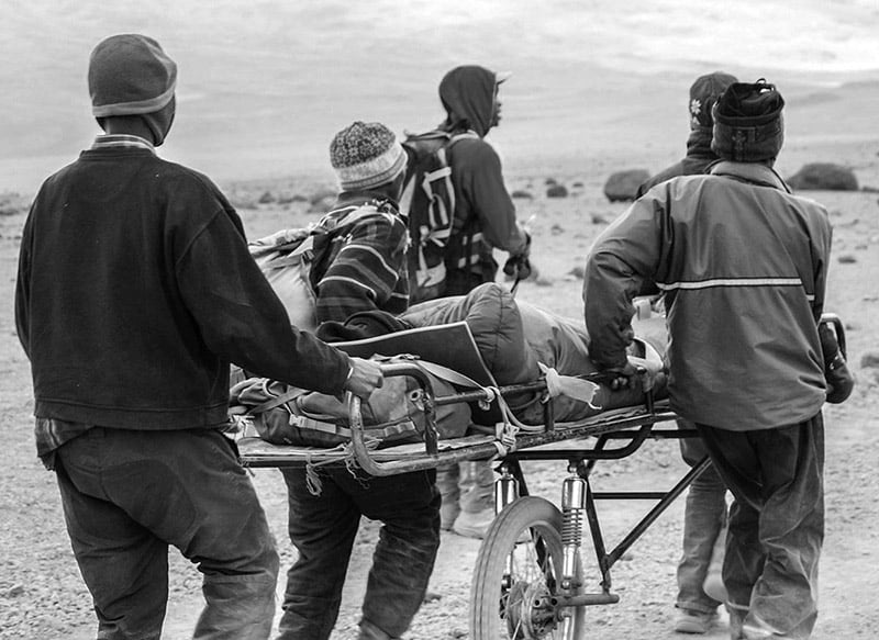 Porters evacuating a climber down Mount Kilimanjaro - Altitude sickness