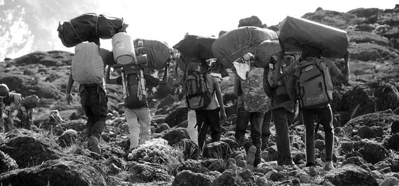 Kilimanjaro porters carrying supplies up the mountain
