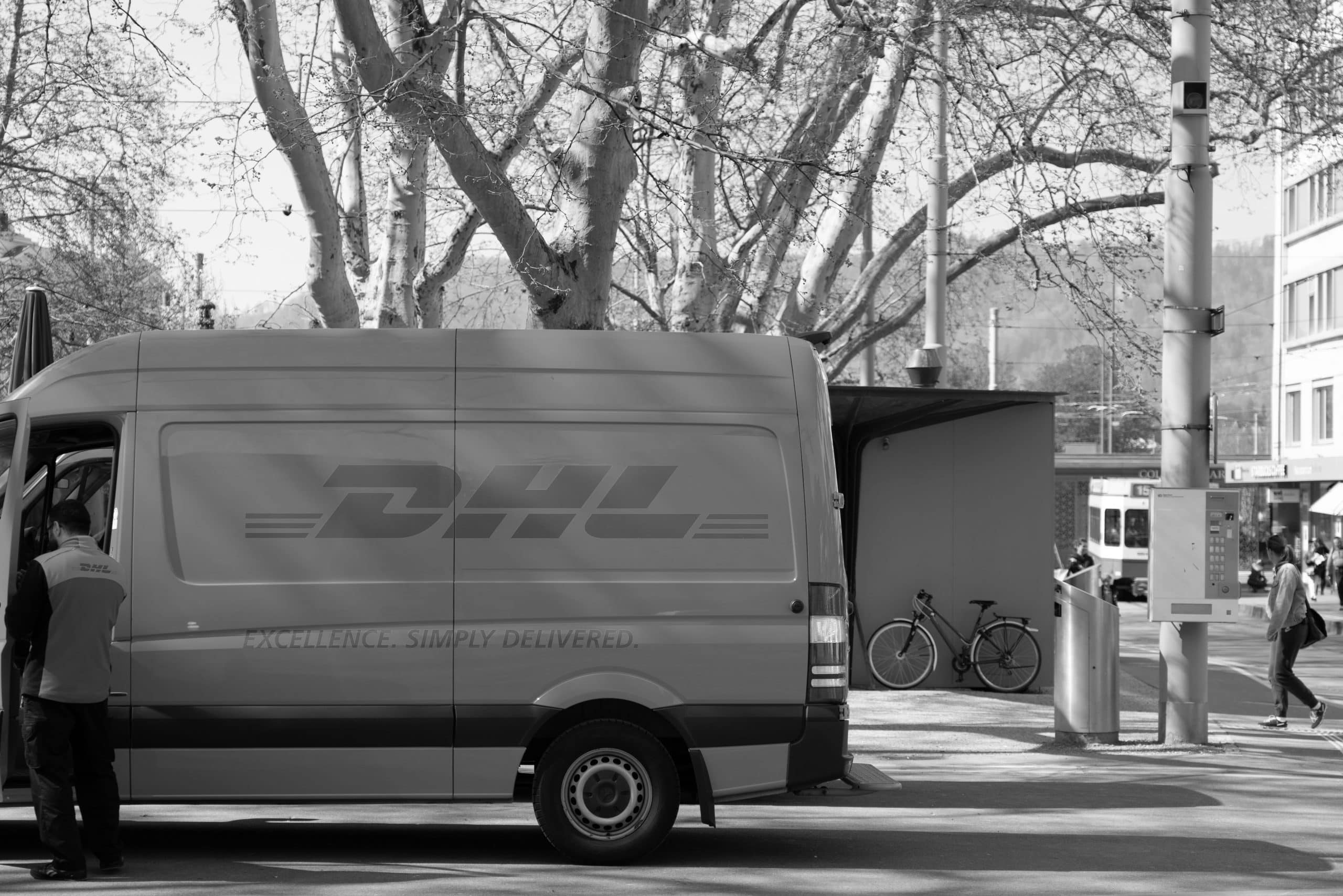 Image of a DHL bus and delivery man