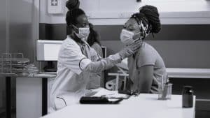 Medical specialist consulting patient with disease while wearing face mask