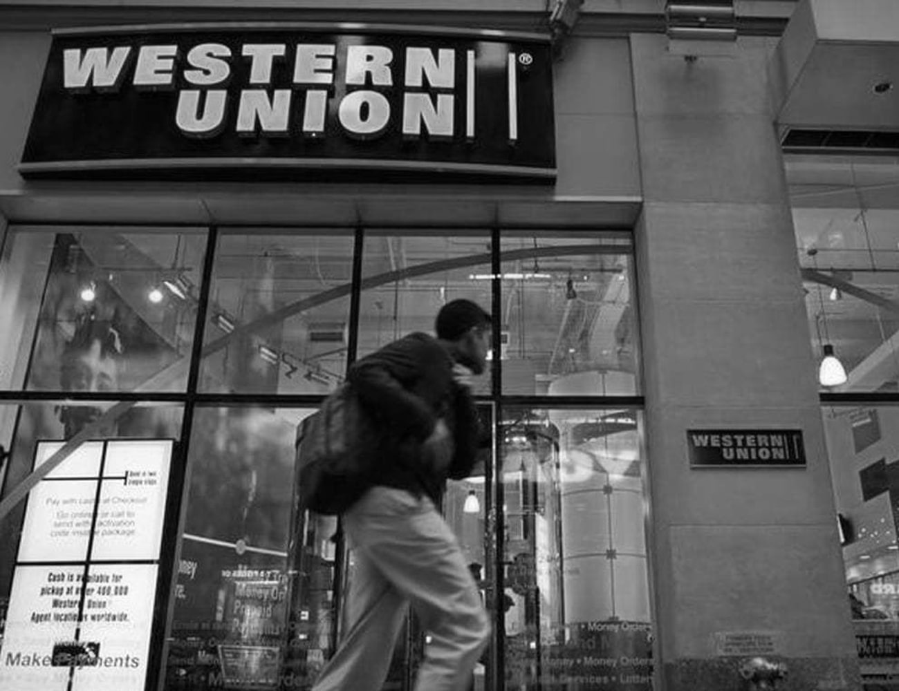 A Man Walking by Western Union Bank Building