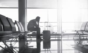 A passenger sitting in an airport lounge waiting for a connecting flight