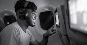A man looking for entertainment on a flight screen