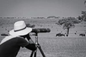A tourist looking at wild animals with telescope