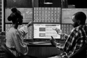 Two people analyzing economic data on their computer